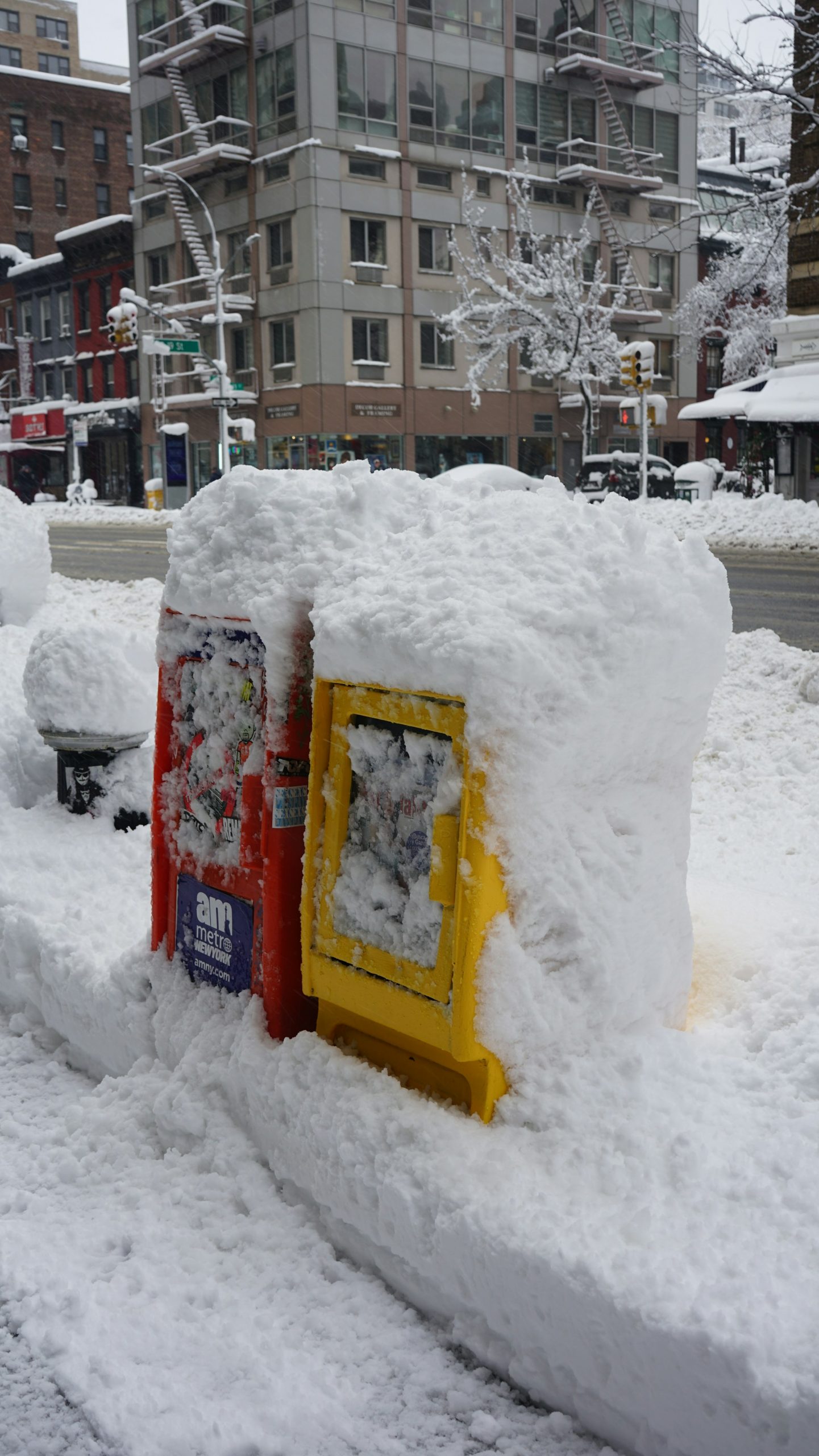 Two newspaper stands, covered in deep snow after the powerful winter system Hernando, on a street in New York.