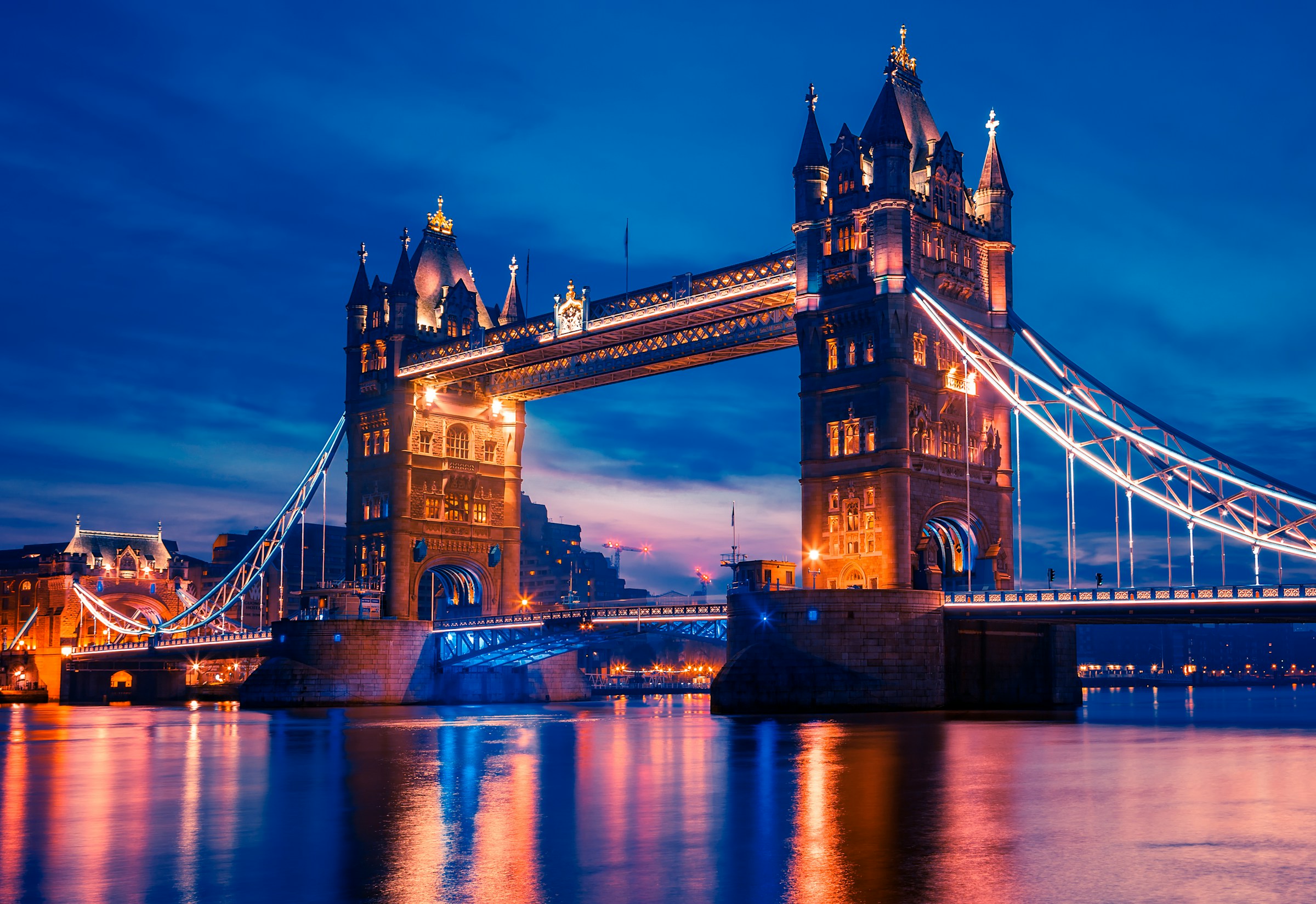 The iconic Tower Bridge at dusk, bathed in royal elegance, with the River Thames flowing in the background.