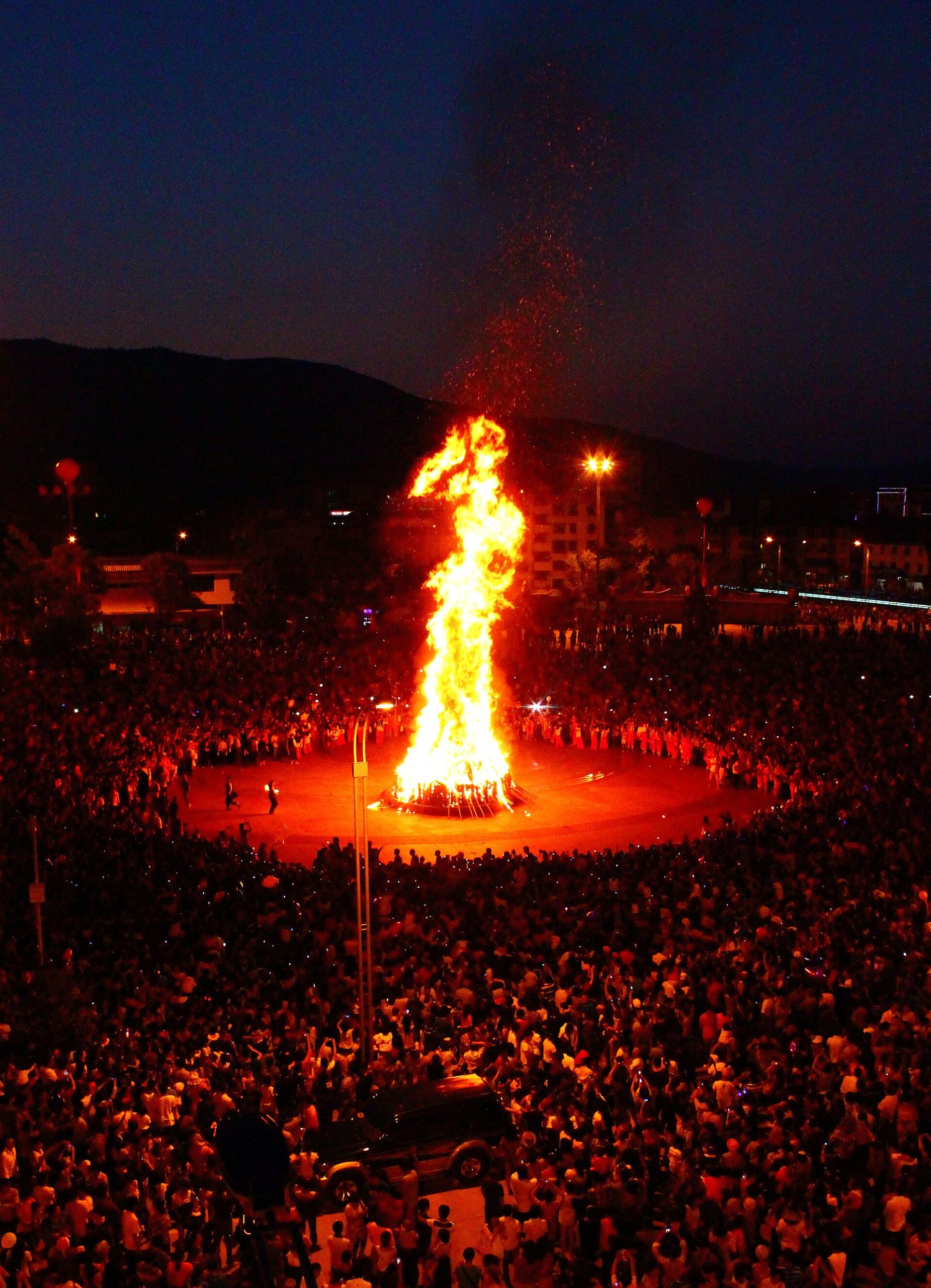 Thousands of pine torches lighting up a mountain night, drums echoing across the valley, and an entire region turning itself over to days of fire, wrestling, and song. This is how southwest China's ethnic minorities celebrate the height of summer.
